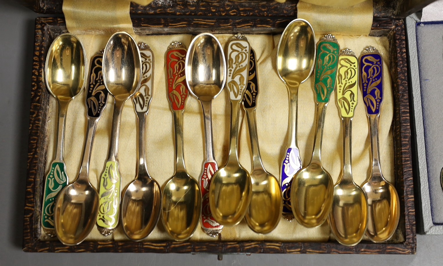 A set of of twelve Danish sterling and polychrome enamel coffee spoons, by W & S Sorenson, 94mm and a similar cased set of six coffee spoons by A. Michelsen.